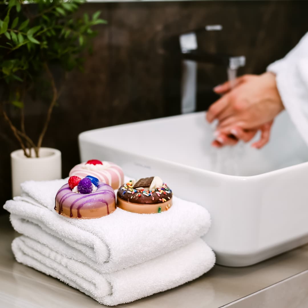 woman using donut soaps in a sink